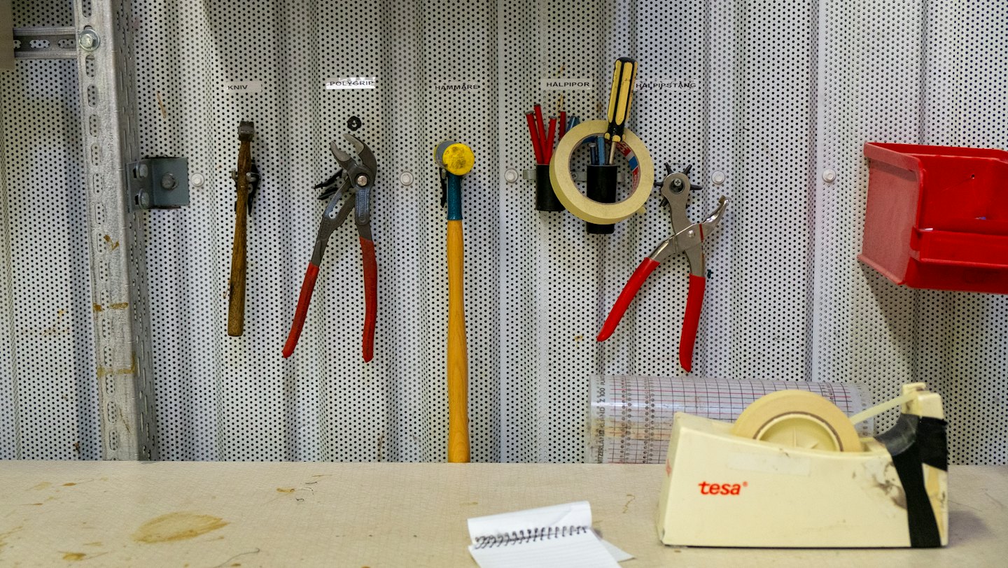 Accueil Outils à main soigneusement disposés sur un panneau perforé au-dessus d'un établi d'artisanat.